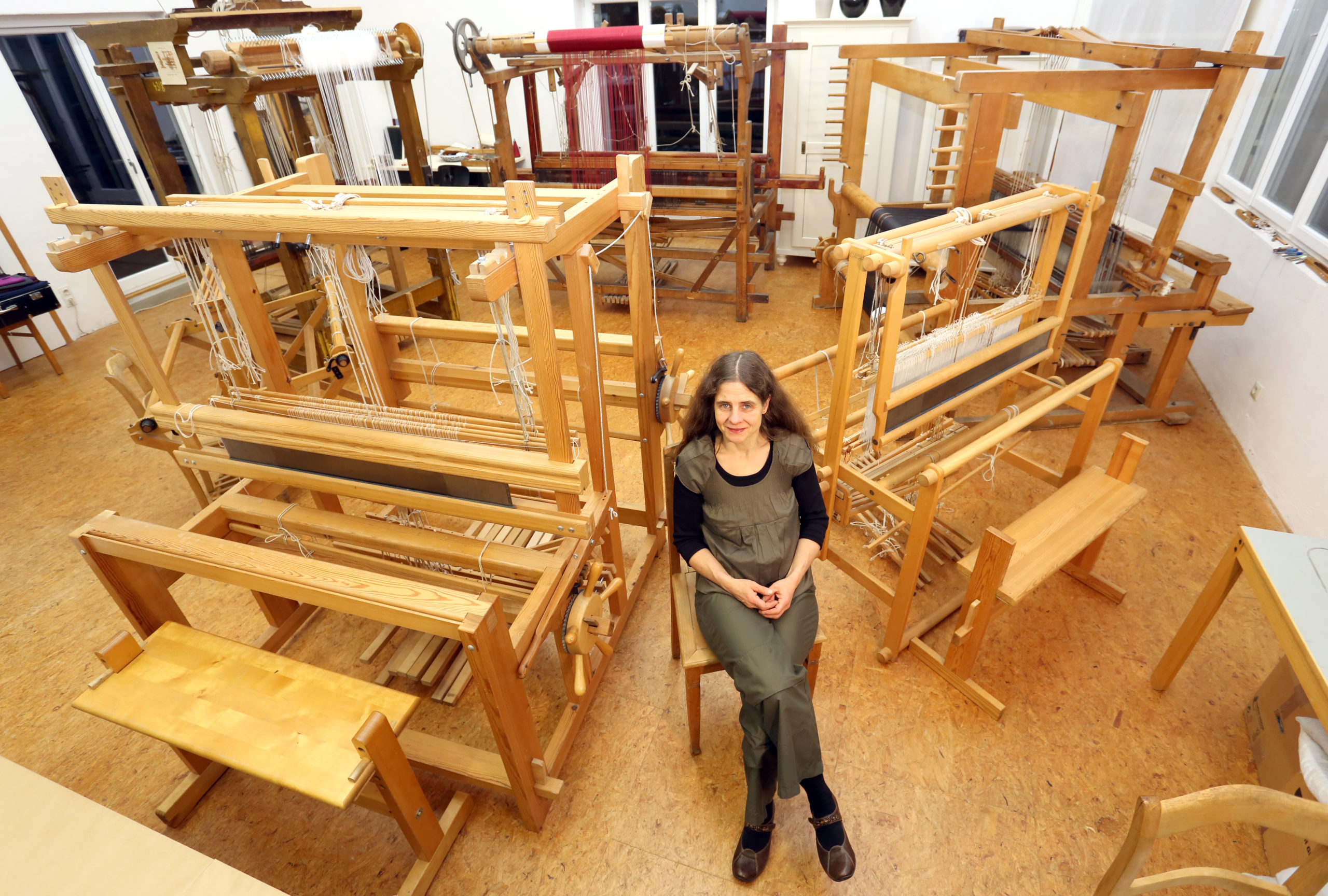 Nadine Cromme in ihrer Handweberei vor den Webstühlen
